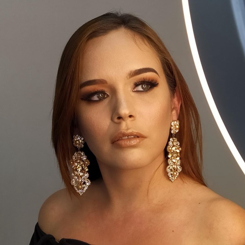 Maquillaje social glam con ojos en tonos marrones cálidos, pestañas voluminosas y labios nude brillantes